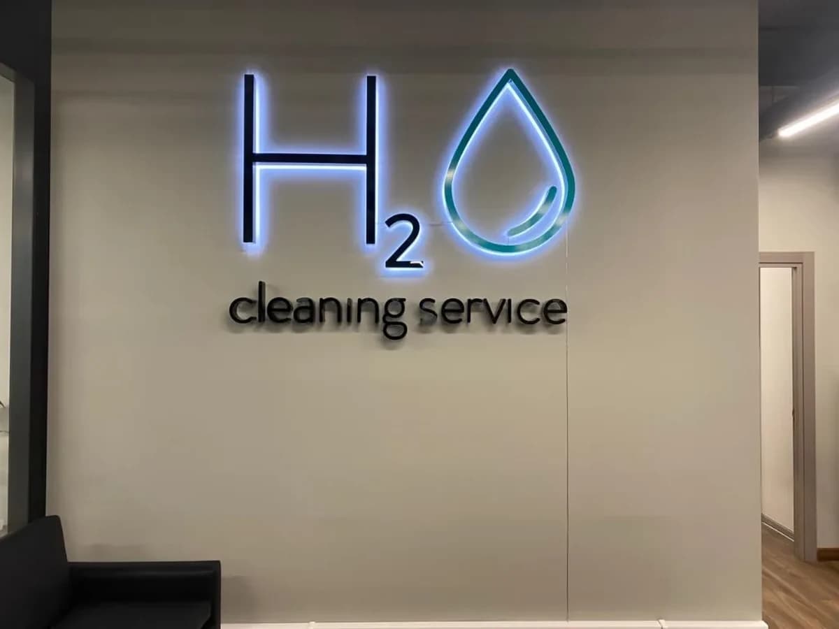 Логотип H2O cleaning service на стене в зале: кабель открыто идёт вдоль стены