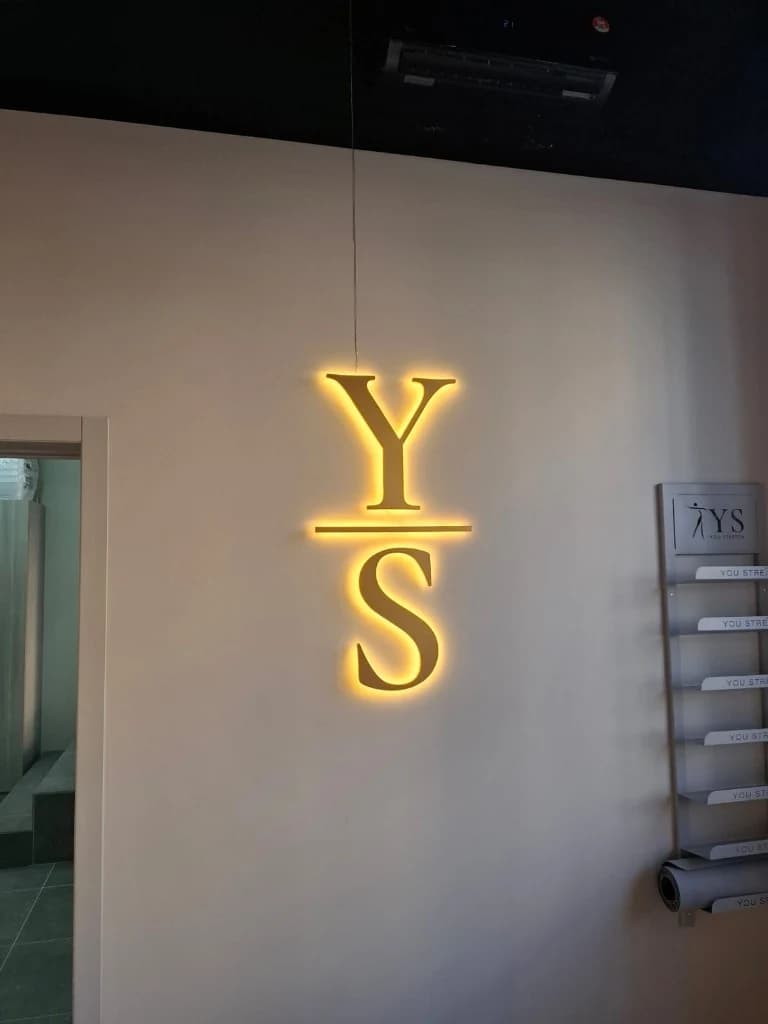 Вывеска YS You Stretch: прозрачный акустический кабель вдоль стены к потолку