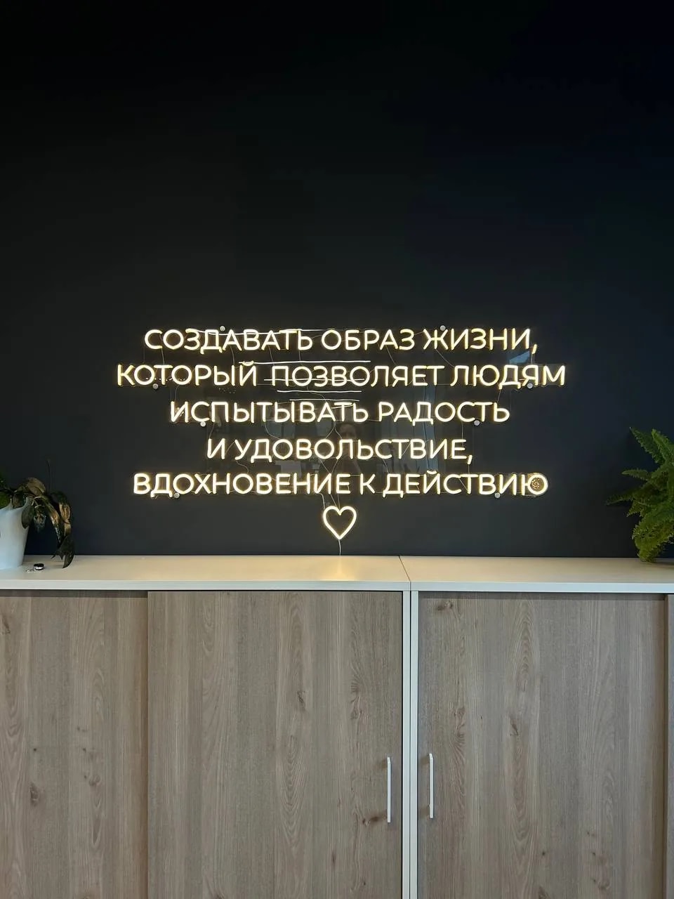 Тёплый белый неон с мотивационной цитатой на стене офиса VDC, Санкт-Петербург