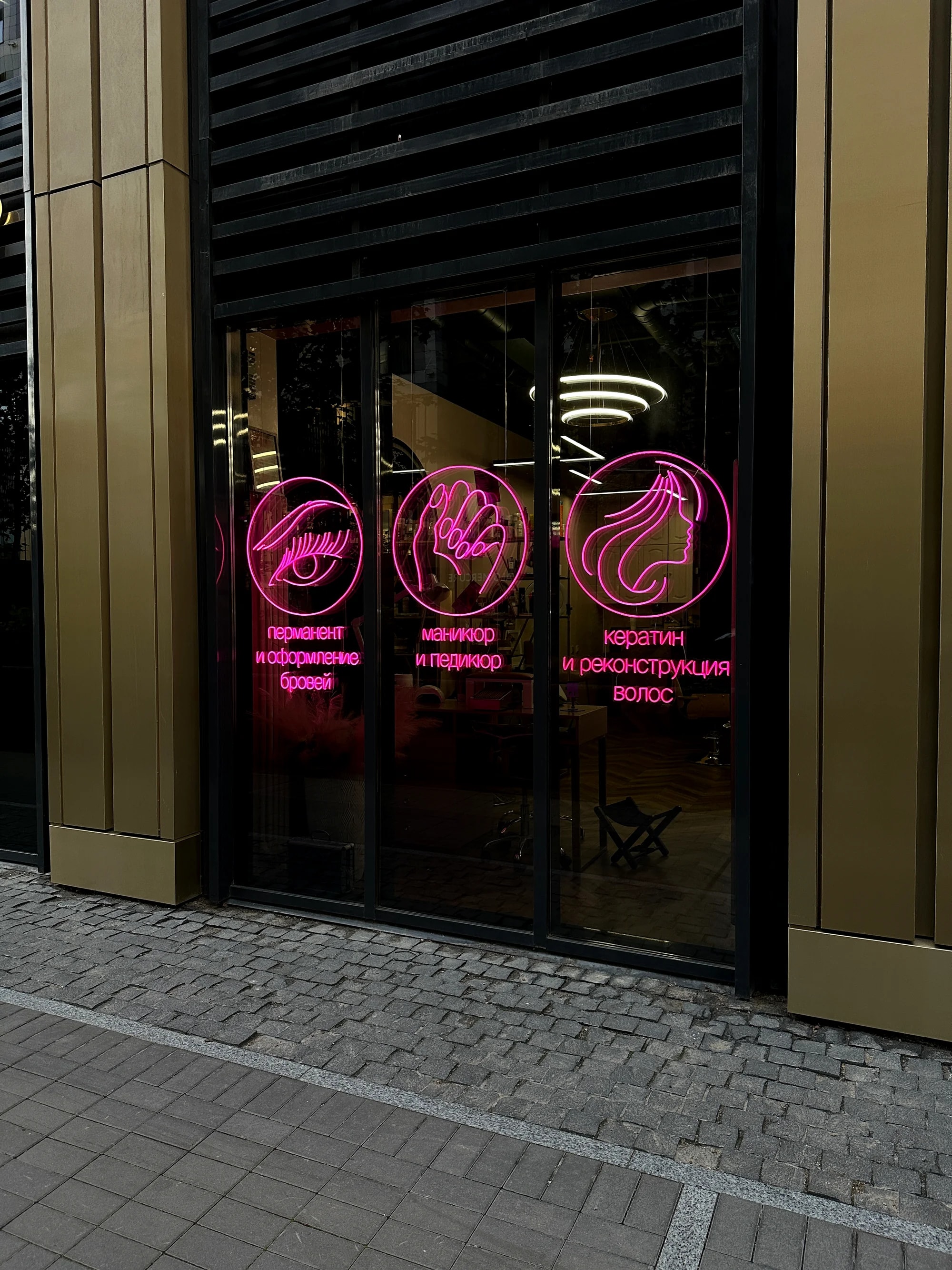 Розовые неоновые вывески с иконками услуг на витринах салона красоты Burns Beauty Bar, ул. Салова, 61, Санкт-Петербург